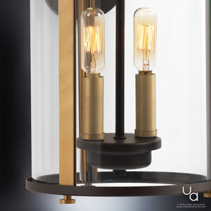 Close-up of the Urban Ambiance UHP1120 Rustic Outdoor Wall Light from the Plymouth Collection, showcasing its olde bronze finish, two exposed filament bulbs, and cylindrical clear glass shade.