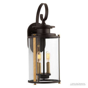 The UHP1120 Rustic Outdoor Wall Light from the Plymouth Collection by Urban Ambiance features an Olde Bronze finish, a clear glass enclosure with two visible exposed bulbs, and a 19.25-inch height by 8-inch width design that beautifully complements both rustic modern sconce styles and traditional outdoor spaces.