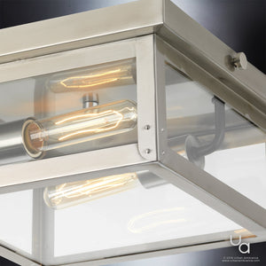 Close-up of the Urban Ambiance Darwin Collection ceiling light, showcasing a modern farmhouse design with a stainless steel finish and glass panels, featuring exposed bulbs and mounted on a dark ceiling.