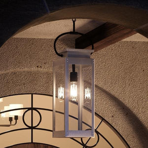 A UHP1134 Modern Farmhouse Outdoor Pendant, 27-3/8"H x 7"W, Stainless Steel Finish from the Darwin Collection by Urban Ambiance hanging from a gorgeous archway