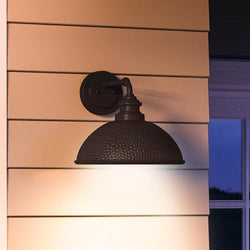 A unique hammered outdoor wall light with a luxury Olde Bronze finish, from the Firenze Collection by Urban Ambiance, showcased on a wooden wall.