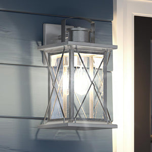 A unique UHP1224 Colonial Outdoor Wall Light, 19"H x 9.125"W, Stainless Steel Finish, Longmont Collection by Urban Ambiance on the side of a house