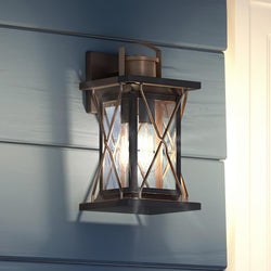 A beautiful Urban Ambiance UHP1232 Colonial Outdoor Wall Light, 13"H x 6.5"W, Olde Bronze Finish from the Longmont Collection on the side of a