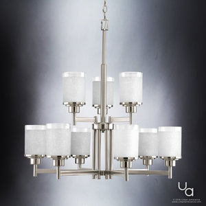 The UHP2021 Contemporary Chandelier from Urban Ambiance’s Cupertino Collection features a brushed nickel finish and a modern two-tier design, each tier supporting four cylindrical frosted glass shades, all suspended by a central rod and chain against a neutral gradient backdrop—an elegant showcase of contemporary style measuring 28.5″ high by 28″ wide.