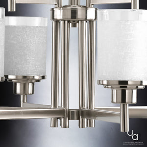 Close-up of the UHP2021 Contemporary Chandelier from Urban Ambiance’s Cupertino Collection, featuring a modern brushed nickel finish and frosted cylindrical glass shades, set against a gradient background.