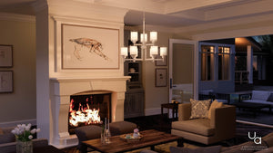 Elegant living room with a lit fireplace, the Urban Ambiance UHP2021 Contemporary Chandelier from the Cupertino Collection—28.5″H x 28″W with a brushed nickel finish and etched umber linen shade—neutral furnishings, artwork above the mantel, and open doors leading to a patio at dusk.