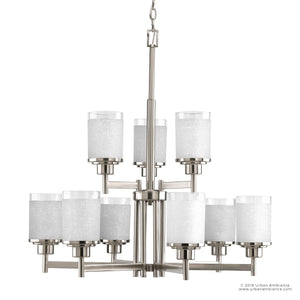 The Urban Ambiance UHP2021 Contemporary Chandelier from the Cupertino Collection showcases a brushed nickel finish and features ten cylindrical frosted glass shades arranged across two elegant tiers, all suspended from a sturdy chain. Measuring 28.5 inches high by 28 inches wide, this modern centerpiece adds sophistication to any space.