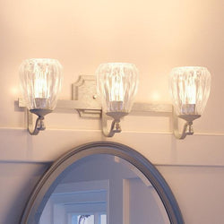 A unique and gorgeous Urban Ambiance UHP2032 Crystal Bathroom Vanity Light, 7.5"H x 23"W, Antique Silver Finish, Ravenna Collection with three light fixtures above a mirror