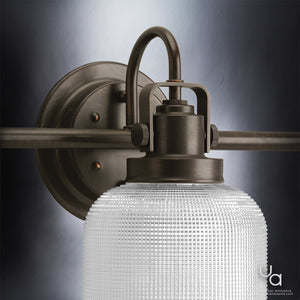 Close-up of the Urban Ambiance UHP2044 Luxe Industrial Bath Fixture from the Harlow Collection, featuring a prismatic glass shade and Fashion Bronze finish, mounted on a neutral background.