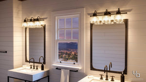Modern bathroom featuring dual sinks, black fixtures, two mirrors, overhead lighting, and a window displaying a cityscape with mountains at sunset. Accented by the Urban Ambiance Harlow Collection UHP2044 Luxe Industrial Bath Fixture (8-3/4″H x 26-1/4″W) in a Fashion Bronze finish.