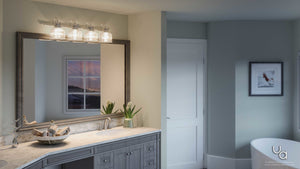 Bathroom featuring a marble countertop, double sink, expansive mirror, and the Urban Ambiance UHP2046 Luxe Industrial Bath Fixture from the Harlow Collection—a prismatic glass shade and polished chrome finish—illuminating the space. The room includes a window at sunset and framed artwork adorning a gray wall.
