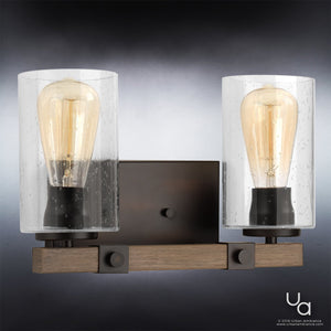 The Urban Ambiance UHP2080 Vintage Bath Fixture from the Darlington Collection features two exposed bulbs and clear glass shades, set on a rectangular base of Olde Bronze finish, blending rustic charm with contemporary style for a modern farmhouse look.