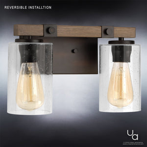 The UHP2080 Vintage Bath Fixture from the Darlington Collection by Urban Ambiance features two exposed bulbs with clear glass shades and is mounted on a rectangular wooden and metal base. Measuring 8″ high by 13-3/8″ wide in an Olde Bronze finish, this modern farmhouse light brings rustic charm and contemporary flair to any space.