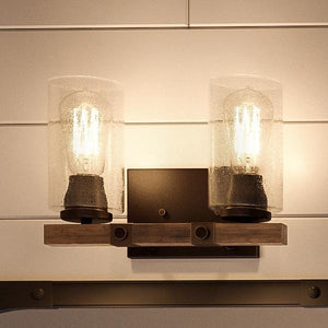 Elevate your space with the Urban Ambiance UHP2080 Vintage Bath Fixture from the Darlington Collection, featuring two exposed bulbs in cylindrical seeded glass shades mounted on a rectangular metal base with an Olde Bronze finish—perfect as a modern farmhouse or vintage bathroom accent. Measures 8″ high by 13-3/8″ wide.