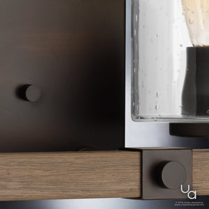 Close-up of the Urban Ambiance UHP2082 Vintage Bath Fixture from the Darlington Collection, featuring an 8-inch high by 32-1/4-inch wide wall-mounted design with an Olde Bronze finish and a clear seeded glass shade detailed with tiny bubbles.