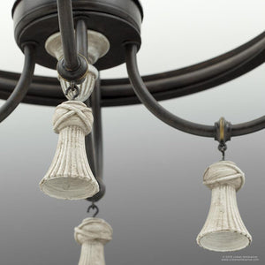 Close-up view of the UHP2102 French Rustic Chandelier from Urban Ambiance’s Alicante Collection, featuring a 27.875″H x 26″W frame in an ancient bronze finish with three decorative white tassel-like ornaments hanging from elegantly curved arms, showcasing French-inspired rustic lighting elegance.