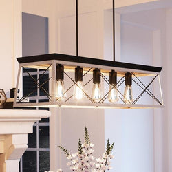 A luxurious UHP2127 Industrial Chic Linear Chandelier, 9"H x 38"W, Charcoal Finish, from the Berkeley Collection beautifully illuminating a living room fireplace.