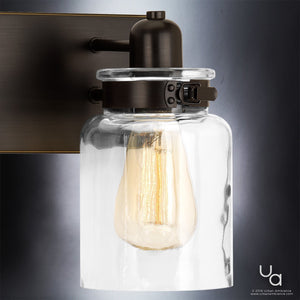 The Urban Ambiance UHP2143 Modern Farmhouse Industrial Bath Fixture from the Bridgeport Collection features a clear glass shade and exposed filament bulb set on an Olde Bronze-finished base—an ideal choice for a vintage bathroom light or timeless industrial style in your bath. Fixture measures 8-5/8″ high by 21-5/8″ wide.