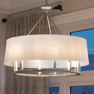 The UHP2182 Cosmopolitan Chandelier from Urban Ambiance’s Marsala Collection, measuring 22.375″ high by 24″ wide with a brushed nickel finish, hangs from the ceiling in front of a window with curtains.