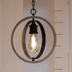 A unique UHP2214 Vintage Pendant, 14"H x 12"W, Charcoal Finish, Anchorage Collection lighting fixture with a circular shape hanging from the ceiling.