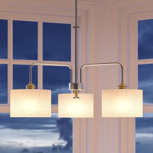Three beautiful UHP2223 Cosmopolitan Chandeliers, 19"H x 25"W, Brushed Nickel Finish, Sheffield Collection by Urban Ambiance in front of a window.
