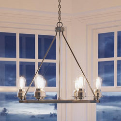 An Urban Ambiance UHP2242 Industrial Chic Chandelier, 27-1/2"H x 28"W, Brushed Nickel Finish, Nashville Collection with four lights in front of a window