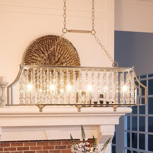 A unique Urban Ambiance UHP2251 Moroccan Island/Linear Chandelier, 13.75"H x 38"W, with an Antique Silver Finish, hanging over a fireplace in a