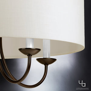 Close-up of the Urban Ambiance UHP2281 Transitional Chandelier from the Aurora Collection, showcasing its Olde Bronze finished arms and two candle-style light fixtures, partially covered by a white fabric lampshade, set against a neutral background.