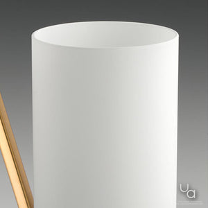A close-up of a white cylindrical shade from the Urban Ambiance Madison Collection’s UHP2301 Contemporary Chandelier (23″H x 27.375″W) in a brushed bronze finish, set against a gray background with a slim wooden detail on the left, evoking the refined look of etched glass often featured in modern chandelier designs.