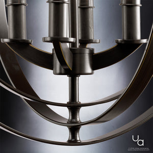 Close-up of the Urban Ambiance UHP2324 Luxe Industrial Chandelier from the Arezzo Collection, featuring a blend of curved and straight elements in an Olde Bronze finish (18-3/8″H x 16″W) set against a gradient background. The Urban Ambiance logo appears in the bottom right corner.