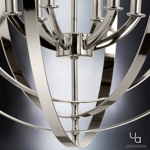 Close-up of the Urban Ambiance UHP2328 Luxe Industrial Chandelier from the Arezzo Collection, featuring a polished nickel finish with gracefully curved metal arms and cylindrical light holders, set against a gradient backdrop.