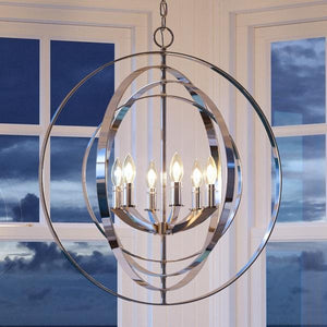 A unique UHP2328 Industrial Chic Chandelier, with a polished nickel finish, hanging in front of a window.