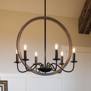 A luxury lighting fixture, the UHP2374 Modern Farmhouse Chandelier in Olde Bronze Finish from the Dunkirk Collection by Urban Ambiance hangs over a dining room table.