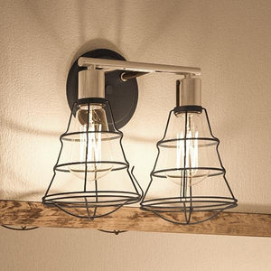 Two luxury Urban Ambiance UHP2420 Vintage Bathroom Vanity Lights, 11"H x 15.625"W, Charcoal Finish, Syracuse Collection, hanging on a wooden wall.