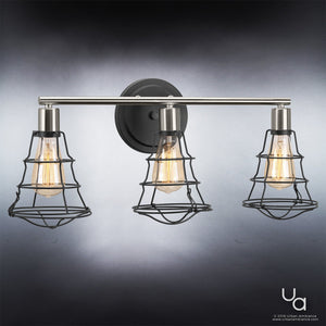 The UHP2421 Vintage Bathroom Vanity Light from the Syracuse Collection by Urban Ambiance features three exposed filament bulbs with black wire cage shades, mounted on a round charcoal-finished wall plate. Measuring 11″ high by 25.125″ wide, this timeless fixture creates a vintage industrial look against any backdrop.