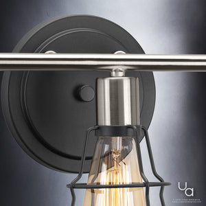 Close-up of the Urban Ambiance UHP2421 Vintage Bathroom Vanity Light from the Syracuse Collection, showcasing an 11-inch high by 25.125-inch wide wall-mounted fixture in a charcoal finish, with an open metal cage design encasing an exposed bulb, set against a gradient background.