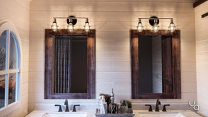 Two wooden-framed mirrors above double sinks with black faucets are illuminated by a pair of UHP2421 Vintage Bathroom Vanity Lights from the Syracuse Collection by Urban Ambiance, each featuring a charcoal finish and measuring 11″H x 25.125″W, bringing a touch of vintage industrial style to this modern bathroom.