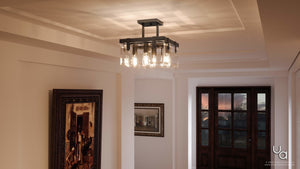 An Urban Ambiance UHP2448 Modern Farmhouse Ceiling Fixture from the Bristol Collection, featuring a 14-inch height and 16-3/4-inch square size in an Olde Bronze finish, graces a white hallway ceiling adorned with framed artwork and large windows overlooking a sunset, creating an elegant look highlighted by its beveled glass accents.