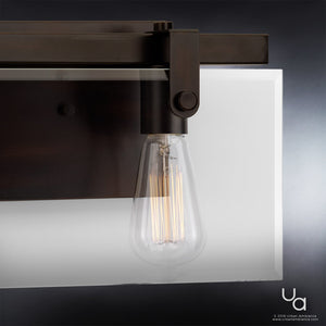 Close-up of a vintage-style exposed filament bulb mounted on the Urban Ambiance UHP2452 Modern Bath Fixture from the Bristol Collection, featuring an Olde Bronze finish and measuring 8-3/8″H x 14-7/8″W, with a frosted glass panel in the background.