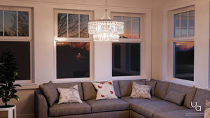 A living room with a gray couch and a gorgeous Urban Ambiance UHP2463 Crystal Crystal Chandelier, 23-7/8
