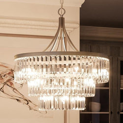 A beautiful UHP2465 Crystal Crystal Chandelier, 29-1/4"H x 28"W, with an antique silver finish, hanging over a dining room table.