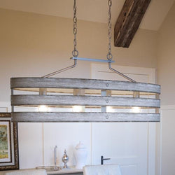 A gorgeous lighting fixture, the UHP2477 Modern Farmhouse Chandelier from the Adelaide Collection by Urban Ambiance, hanging over a dining room table.