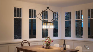 A wooden dining table adorned with flowers, wine, and two glasses is set beneath the Urban Ambiance UHP2492 Mid-Century Modern Industrial Chandelier from the Palma Collection, featuring a striking geometric design and an Olde Bronze finish, in a room with large windows.