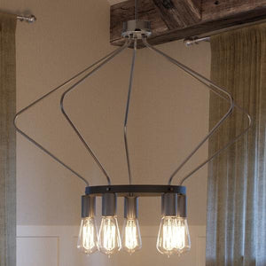 A gorgeous lighting fixture, the Urban Ambiance UHP2493 Mid-Century Modern Industrial Chandelier, features a beautiful brushed nickel finish and four light bulbs hanging over a dining room table.