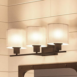 An Urban Ambiance Tacoma Collection bathroom vanity with two UHP2513 Cosmopolitan Bathroom Vanity Lights, 7.375"H x 23.5"W, in Olde Bronze Finish, and