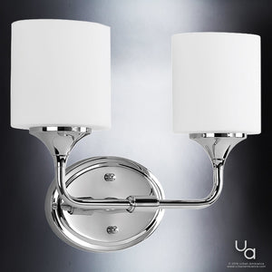 The UHP2570 Contemporary Bathroom Vanity Light from the Coventry Collection by Urban Ambiance features a polished chrome finish and two cylindrical etched opal glass shades mounted on an oval base, making it a perfect modern choice for elevating your bathroom lighting.