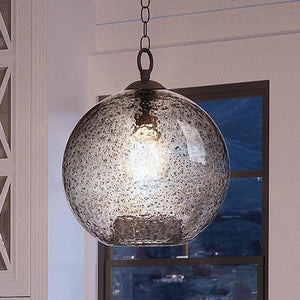 A UHP2580 Vintage Pendant from the Birmingham Collection by Urban Ambiance, featuring a 14-inch height and 11-3/4-inch width with a charcoal finish, hangs in front of a window and casts light throughout the modern room.