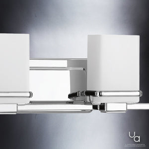 Close-up of the Urban Ambiance UHP2605 Transitional Bathroom Vanity Light from the Modena Collection, featuring a polished chrome finish and two etched opal glass shades. Measuring 6.5″ high by 31.25″ wide, this elegant fixture is mounted on a metallic wall plate and exemplifies modern bathroom lighting. The frosted glass diffuses light beautifully, creating a soft and inviting ambiance.