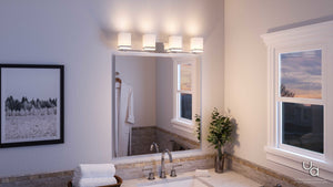 Modern bathroom featuring the Urban Ambiance UHP2605 Transitional Bathroom Vanity Light from the Modena Collection, showcasing a polished chrome finish and etched opal glass shades above the mirror. The space also includes a framed photo, white robe hanging on a hook, sink with rolled towels, a plant, and a window framing views of the sunset sky.