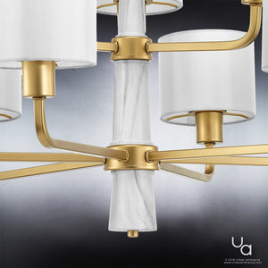 Experience a close-up of the Urban Ambiance UHP2630 XL Cosmopolitan Chandelier from the Oxford Collection, measuring 25″ high by 36″ wide in a Palladian Gold finish, showcasing multiple arms adorned with cylindrical white lampshades and sophisticated marble accents set against a gradient background.